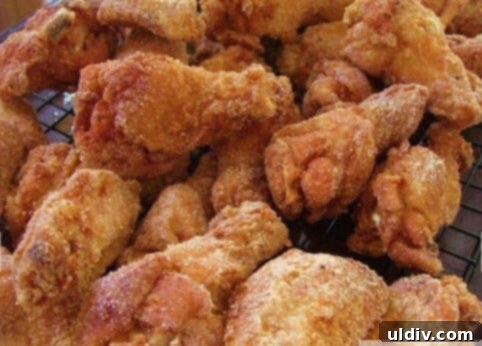 Fried chicken wings cooling on a wire rack.