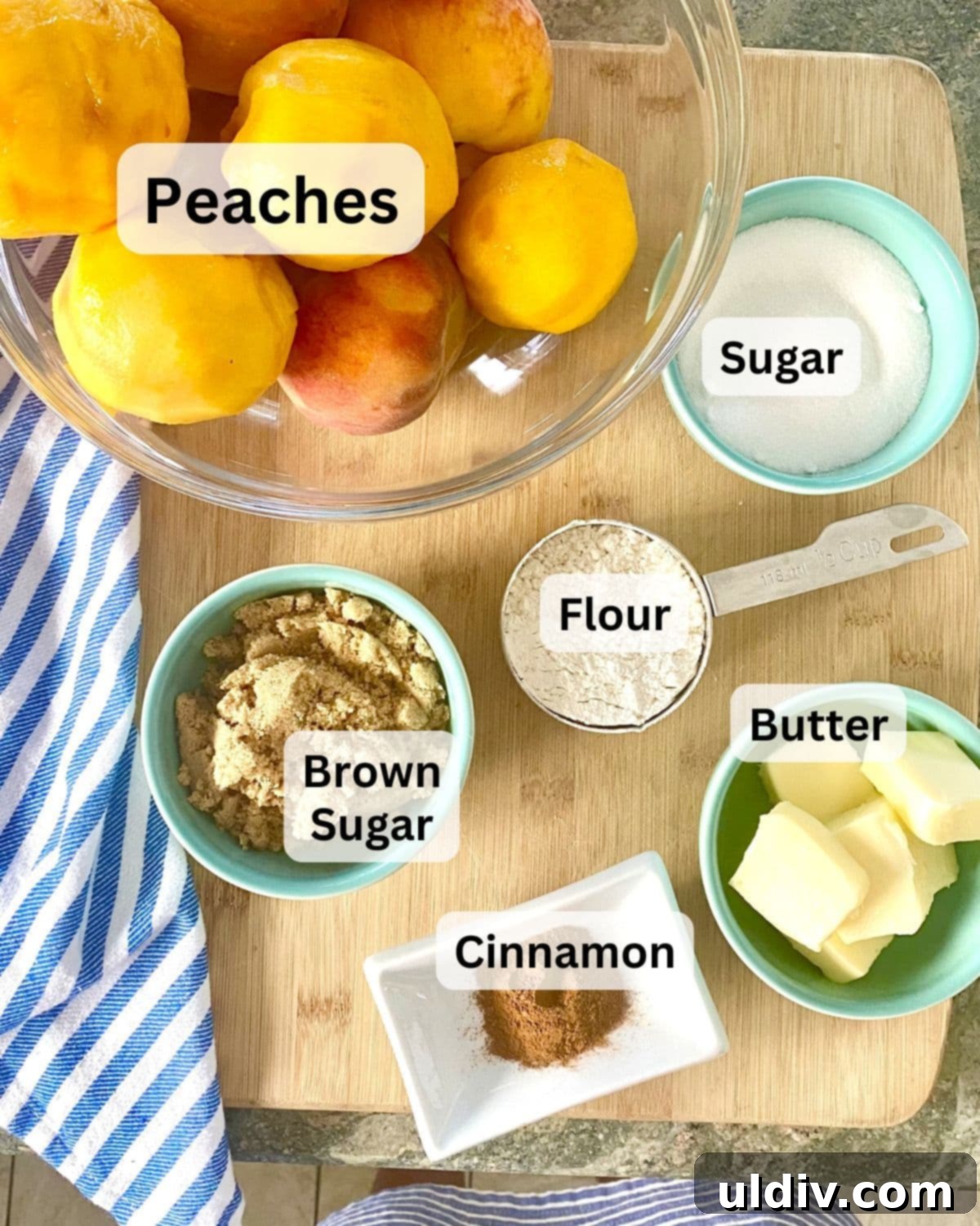 Perfect Peach Crumble Pie 5 A collection of ingredients for peach crumble pie: fresh peaches, butter, flour, sugar, cinnamon, and brown sugar neatly arranged on a wooden cutting board.
