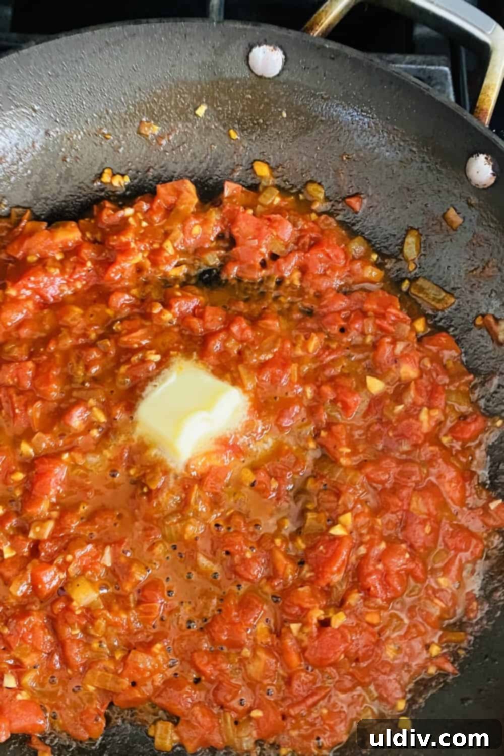 Pan-Seared Chicken with a Sun-Kissed Tomato, Wine & Basil Reduction 7 adding butter to tomato pan sauce