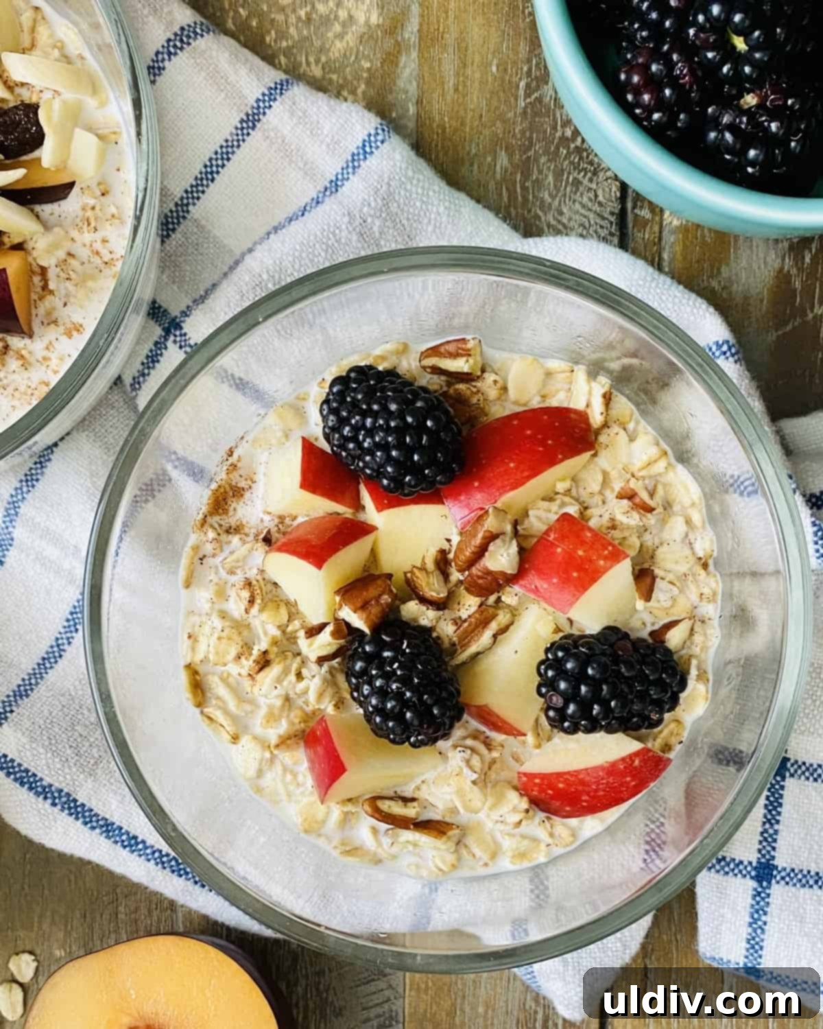 Effortless Overnight Oats 2 Overnight oats with crisp apples, juicy blackberries, and crunchy pecans, ready for a healthy breakfast.