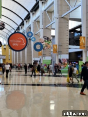 Experiencing and Evaluating the 2023 National Restaurant Association Show 4 A wide shot of the bustling exhibition floor at the National Restaurant Association Show, showing numerous booths and attendees.