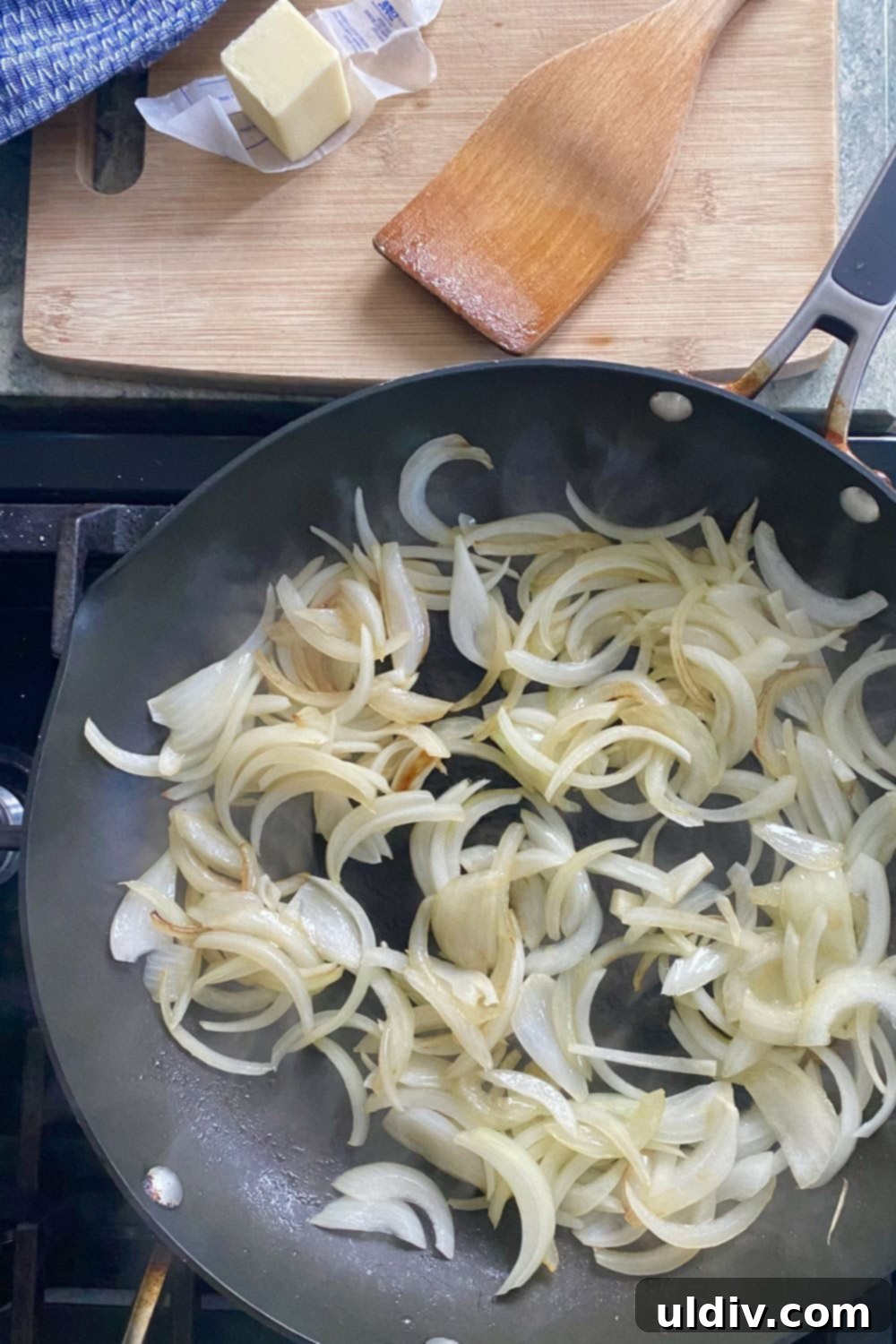 30-Minute Sausage and Pea Pasta 4 Sauteing sliced onions in a pan with butter.