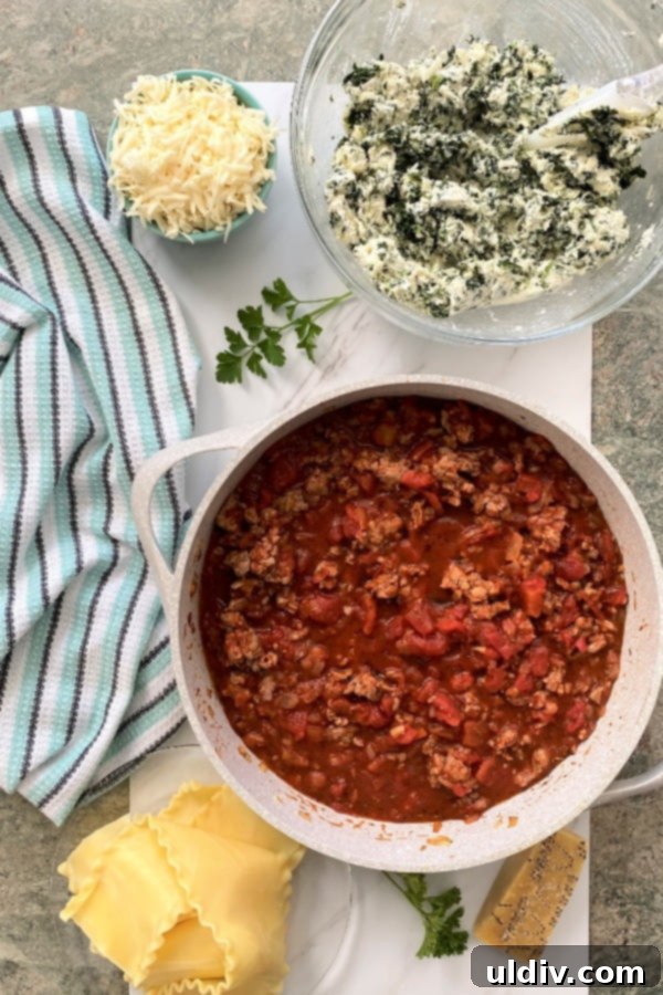 Hearty Spinach and Sausage Lasagna 5 ingredients for making an Italian pasta recipe - bowls of 3 cheese mixtures, a bowl of tomato sauce, pasta, and extra cheese