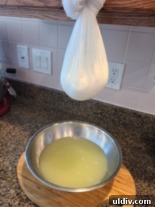 The Sour Milk Secret Homemade Cheese and Happy Memories 5 Cheesecloth bundle hanging from a kitchen cabinet knob, draining whey