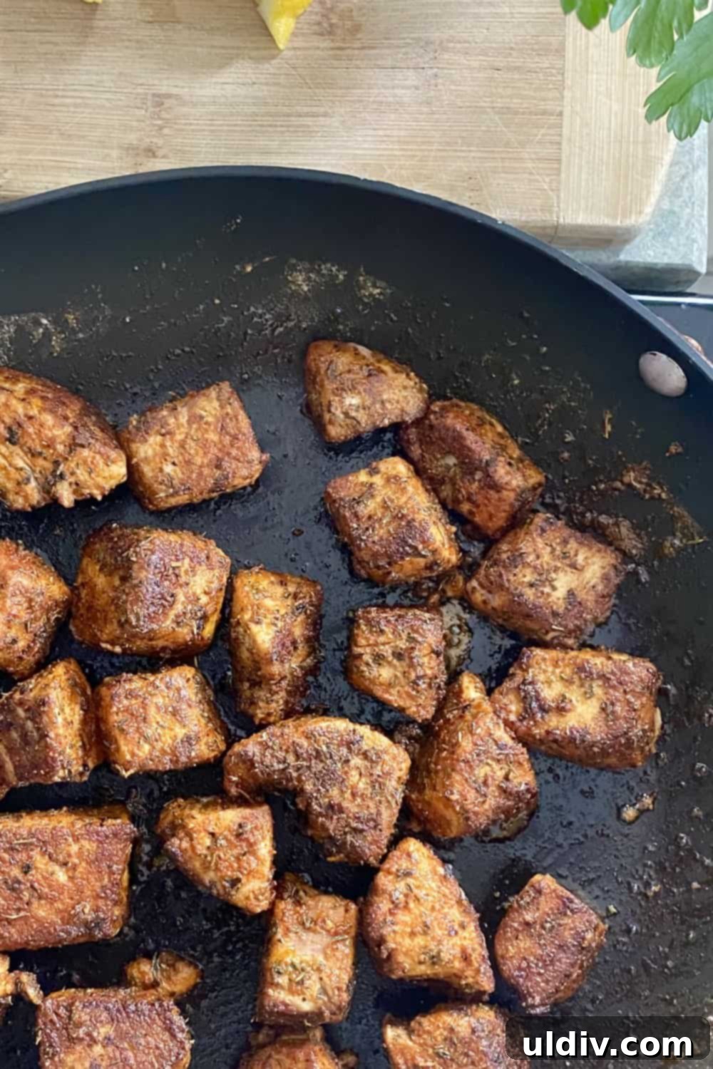 Spiced Tuna Poppers with Tangy Pickle Dip 8 Bite-sized seasoned tuna pieces being quickly sautéed in a hot pan, developing a rich crust.