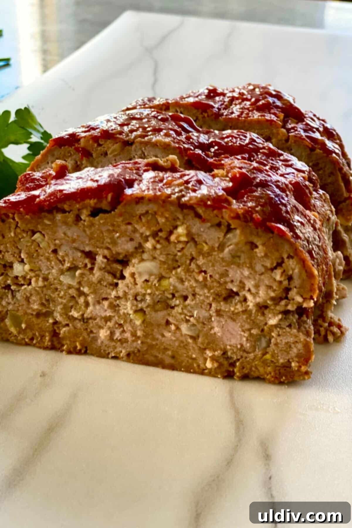 The Ultimate Mom's Meatloaf 7 3 slices of mom's meatloaf on a white marble counter.