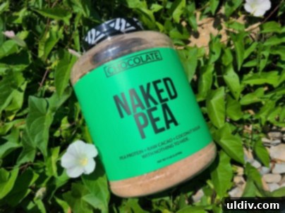 Naked Nutrition Chocolate Pea Protein Powder A Deliciously Wholesome Review 3 A close-up of a Naked Nutrition Chocolate Pea Protein Powder container on a wooden surface.