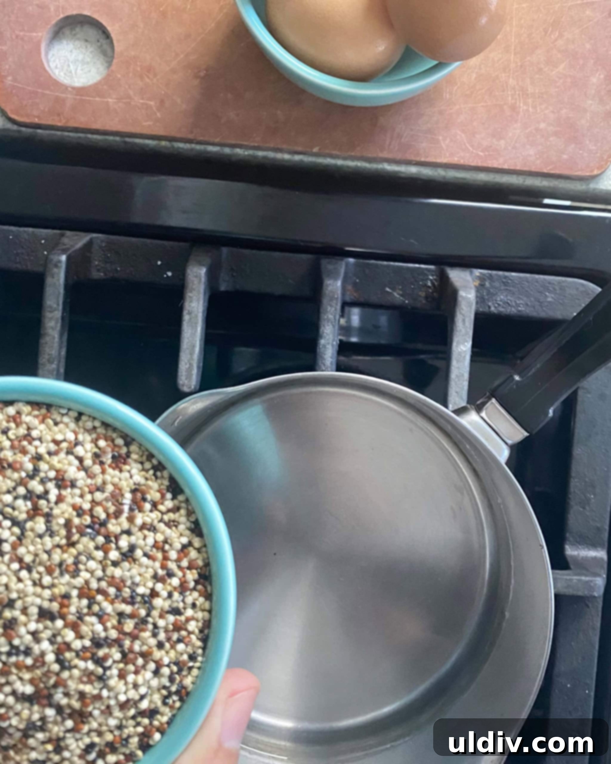 Fuel Your Morning: Savory Quinoa Bowl with Eggs, Sausage & Spinach 4 Adding dry quinoa to boiling water in a saucepan for cooking.