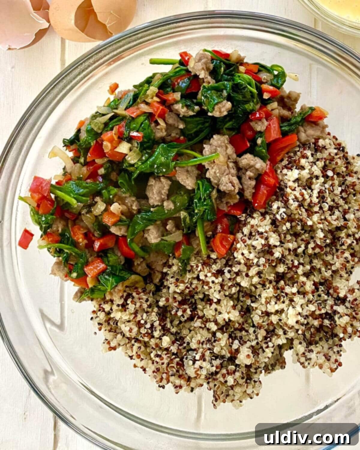 Fuel Your Morning: Savory Quinoa Bowl with Eggs, Sausage & Spinach 6 A bowl containing a mix of fluffy cooked quinoa, sautéed vegetables, and crumbled breakfast sausage, ready for the eggs.