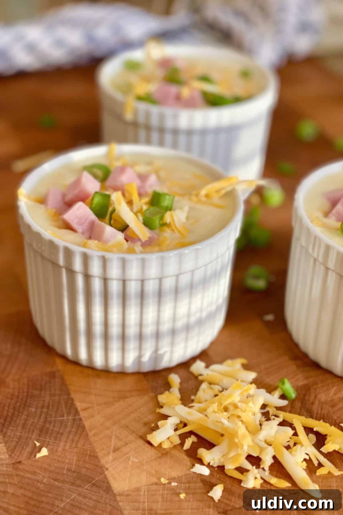 30-Minute Easy Cheesy Ham and Potato Soup 9 3 bowls of creamy soup topped with ham and shredded cheese.