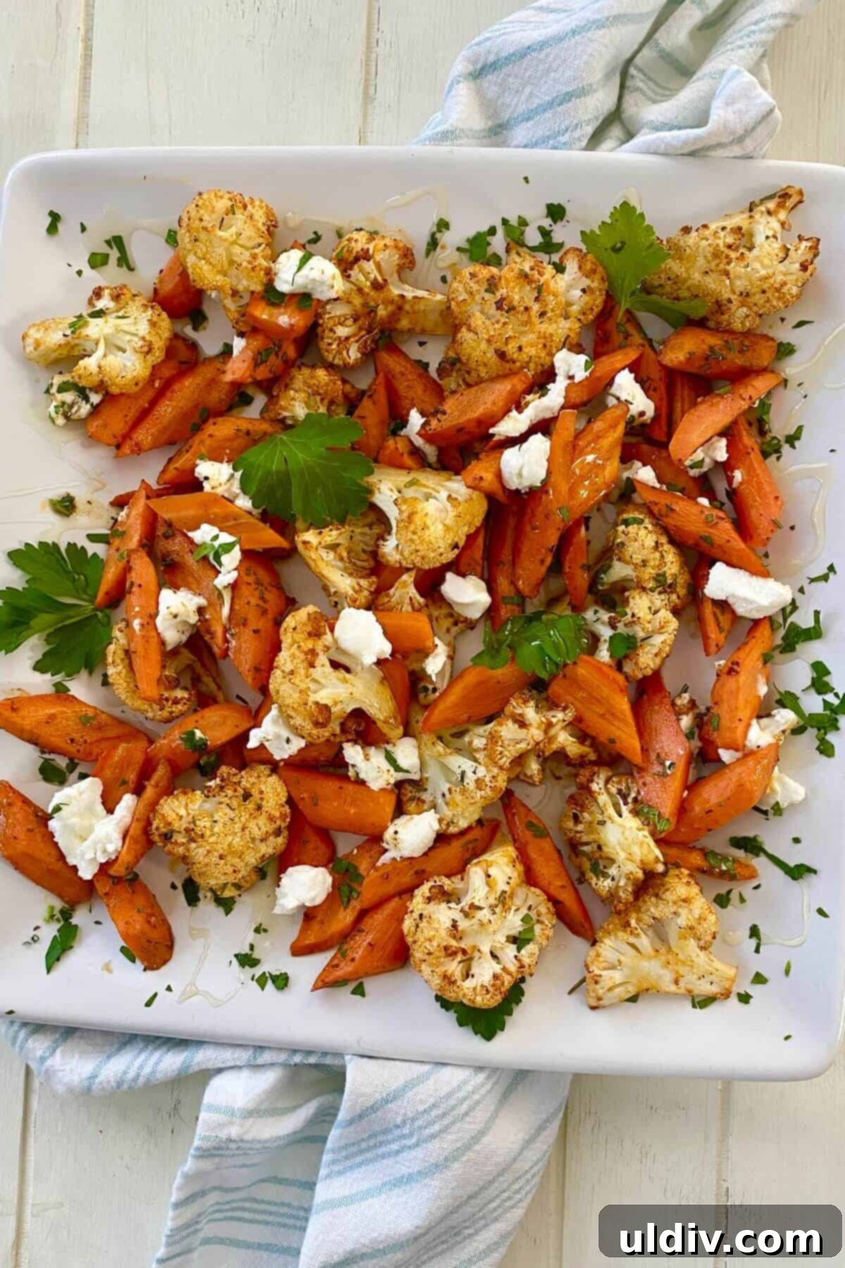 Honey-Glazed Roasted Carrots and Cauliflower with Tangy Goat Cheese 8 A serving of roasted carrots and cauliflower with goat cheese on a plate.
