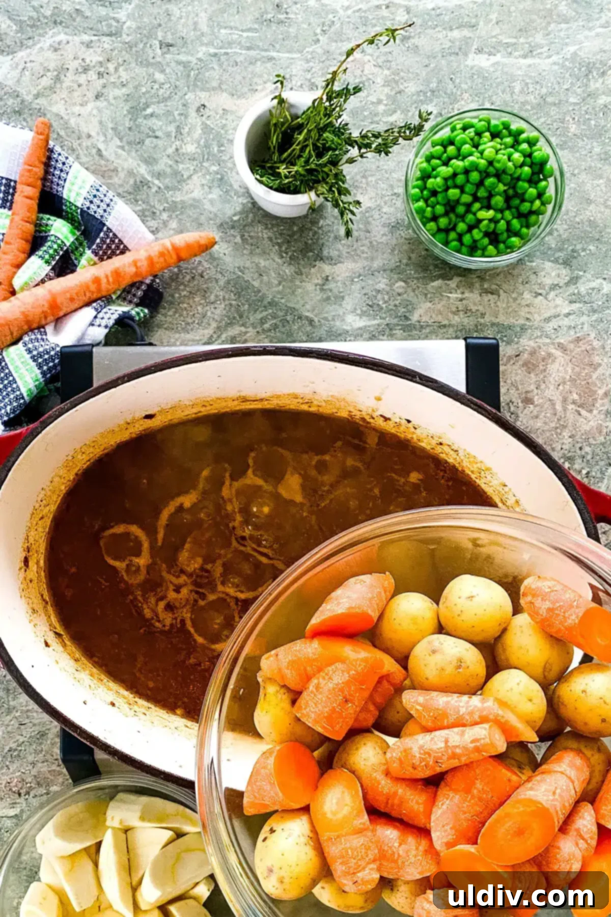 Hearty Guinness Lamb Stew 6 Adding diced carrots, parsnips, and potatoes to the simmering hearty Irish stew in a Dutch oven