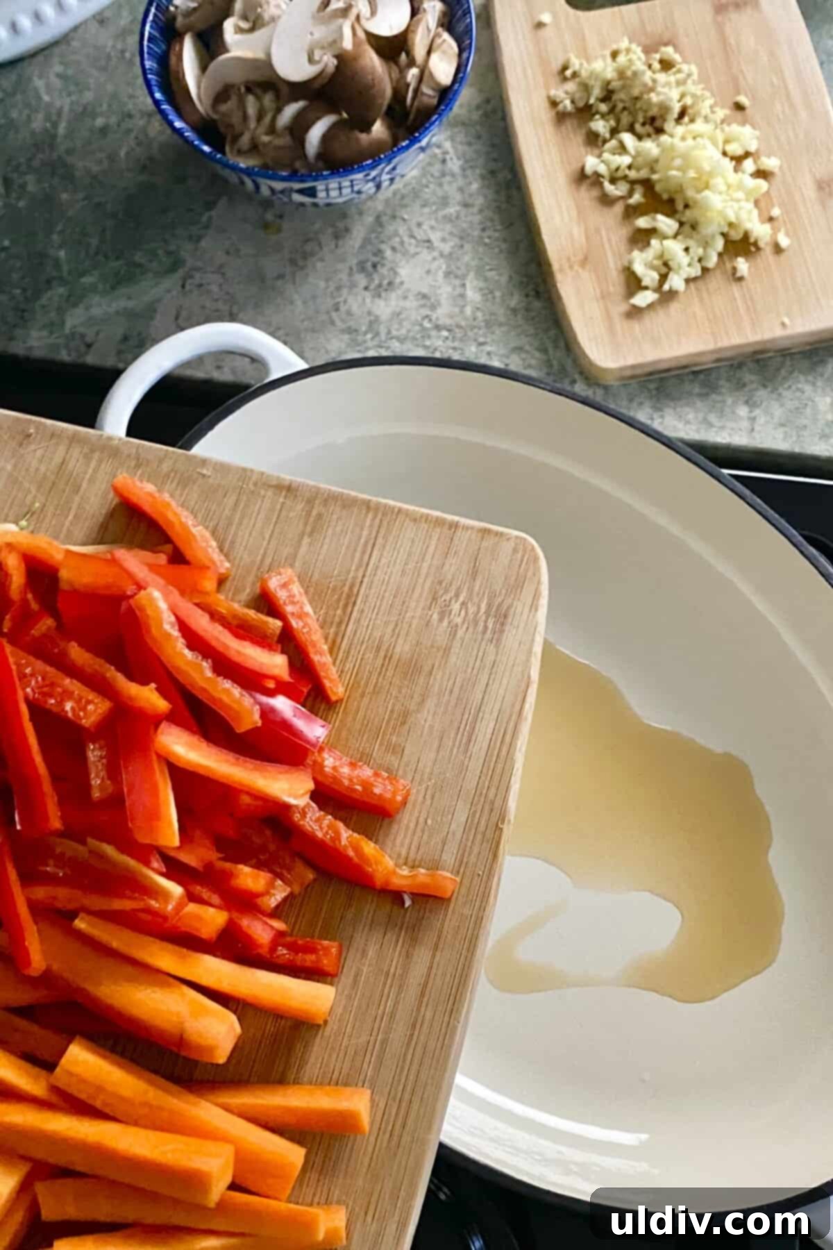 adding carrots and red peppers to sauté pan.
