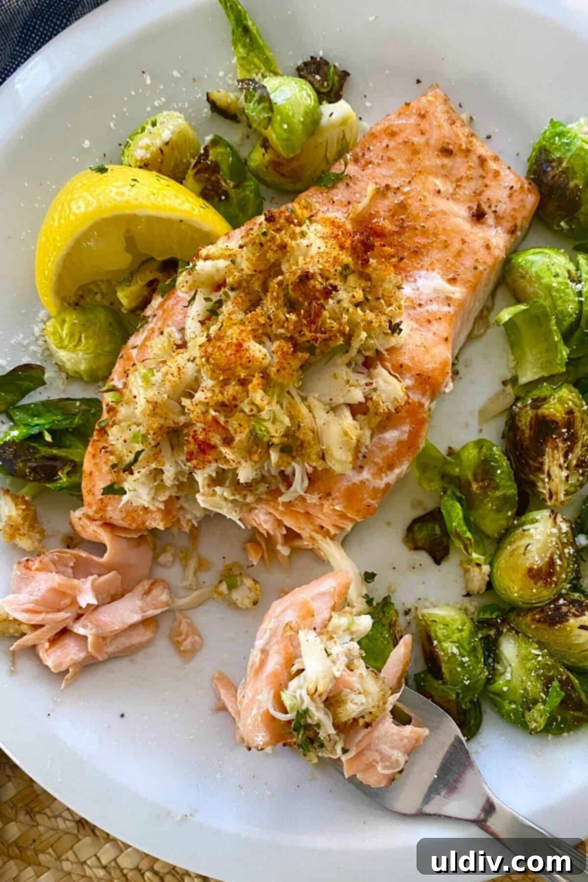 Crab-Filled Salmon Perfection 8 A perfectly baked crab stuffed salmon fillet, with a bite taken out, revealing the succulent crab filling, served with a lemon wedge.