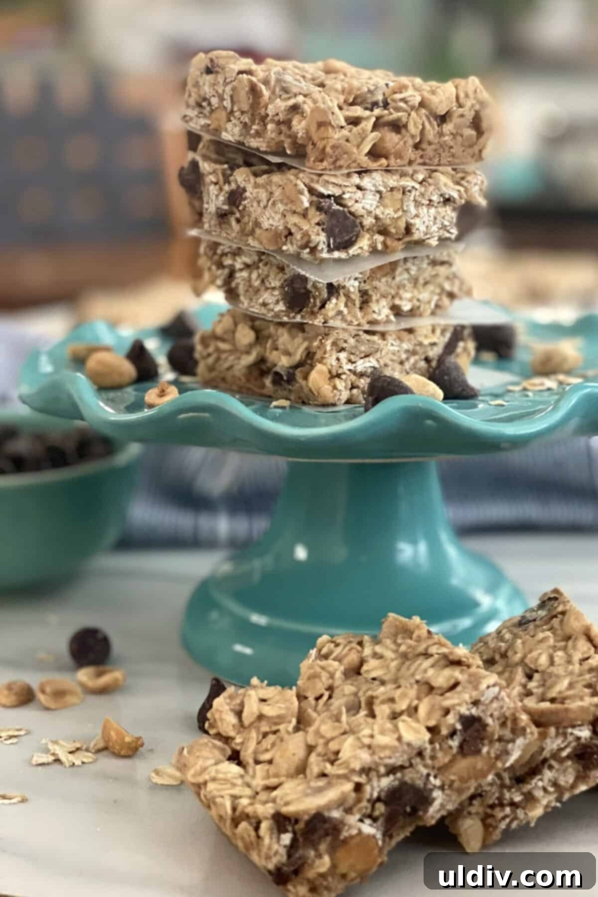 Scrumptious Peanut Butter Chocolate Chip Oat Bars 9 Four peanut butter oat bars stacked on a small white plate, ready to be enjoyed.