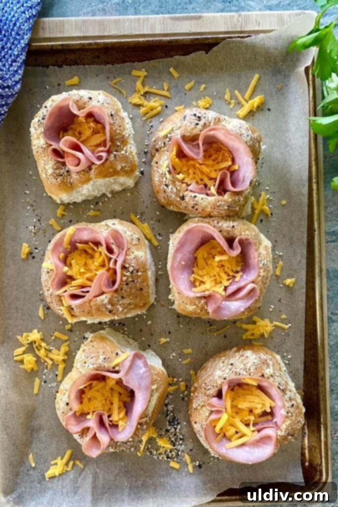 Ham and Egg Bread Bowls 7 Bread bowls filled with ham and a generous layer of shredded cheese, ready for the eggs.