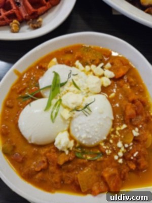 Chicago Waffles: A Delightful Brunch for Women's Day Weekend 8 A hearty Shakshuka with feta, featuring poached eggs in a rich tomato sauce, served with hummus and toast, a savory delight from Chicago Waffles.