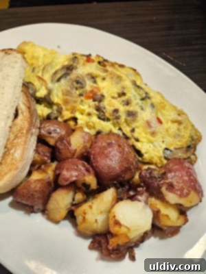 Chicago Waffles: A Delightful Brunch for Women's Day Weekend 9 A substantial Steak Omelette, packed with skirt steak, vegetables, and cheese, served with signature red potatoes and toast, a hearty brunch option.