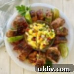 A sliced pork tenderloin on a plate with a mango salsa.