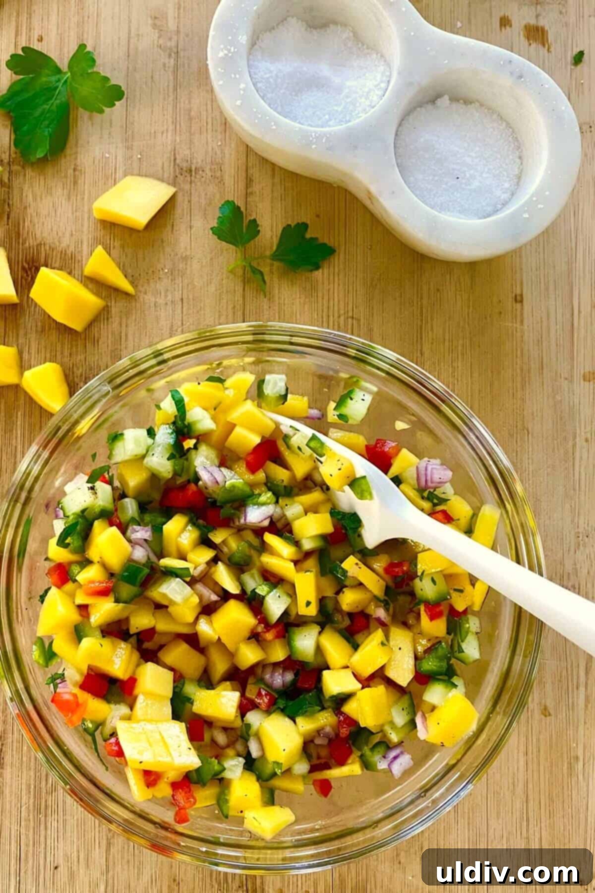 Tropical Heat Pork Tenderloin 7 A mango salsa in a bowl with a spoon.