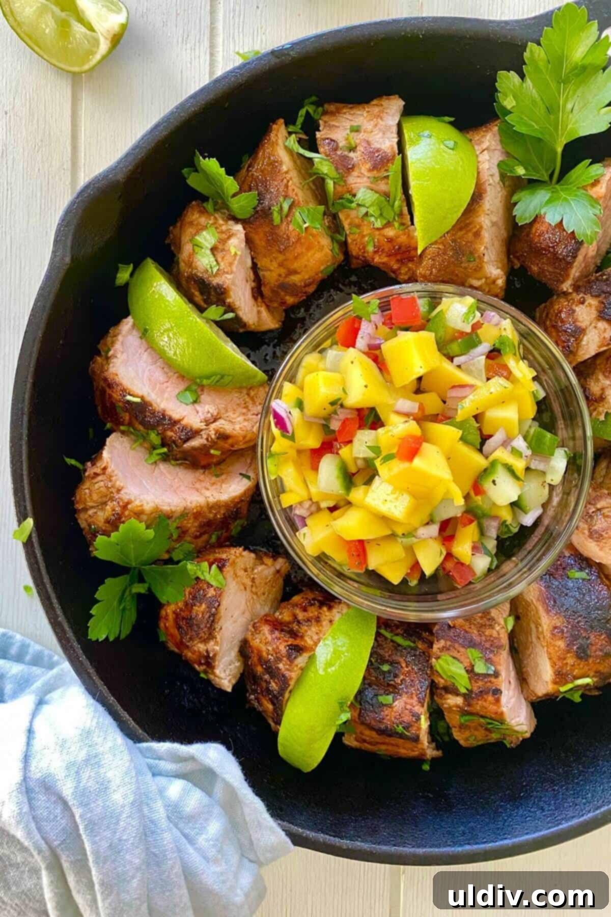 Tropical Heat Pork Tenderloin 9 A sliced pork with mango in a cast iron skillet.