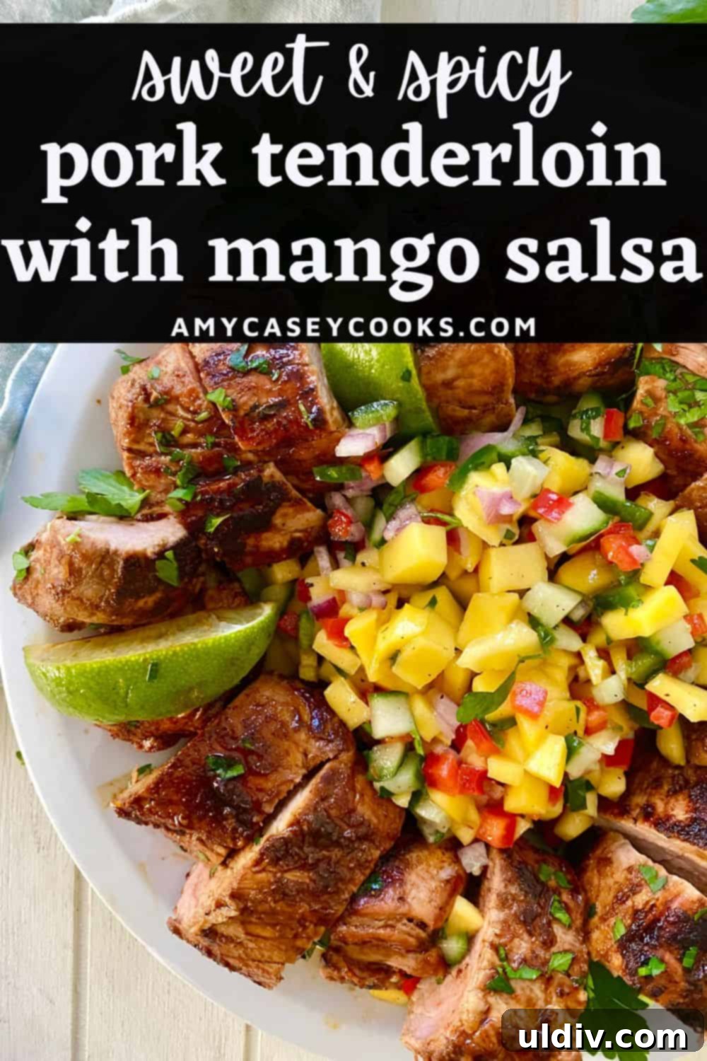 Tropical Tango Pork Tenderloin with Mango Salsa 10 A beautifully presented plate of sliced pork tenderloin with a vibrant mango salsa, garnished with fresh lime wedges, ready to be served.