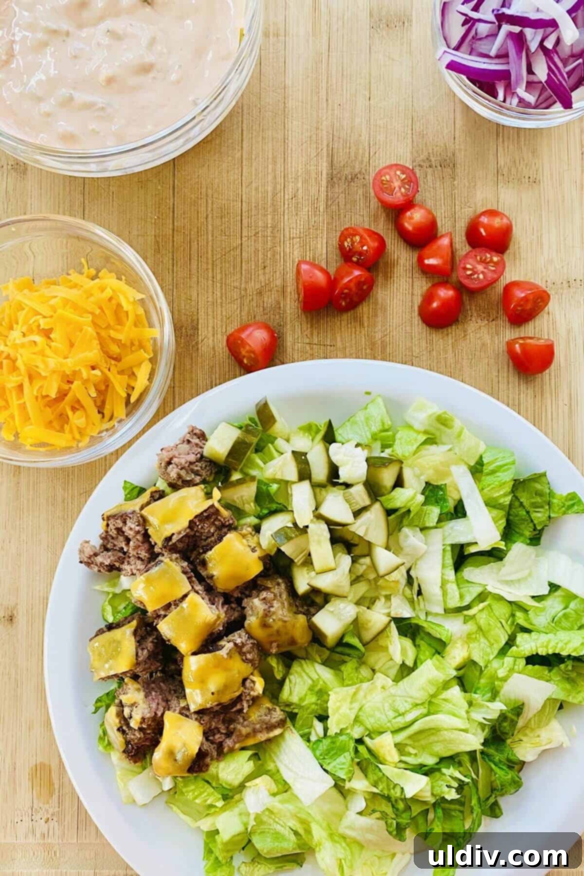 Loaded Big Mac Bowl 8 Layers of lettuce and bite-sized cheeseburger pieces being assembled on a plate for a Big Mac Bowl.