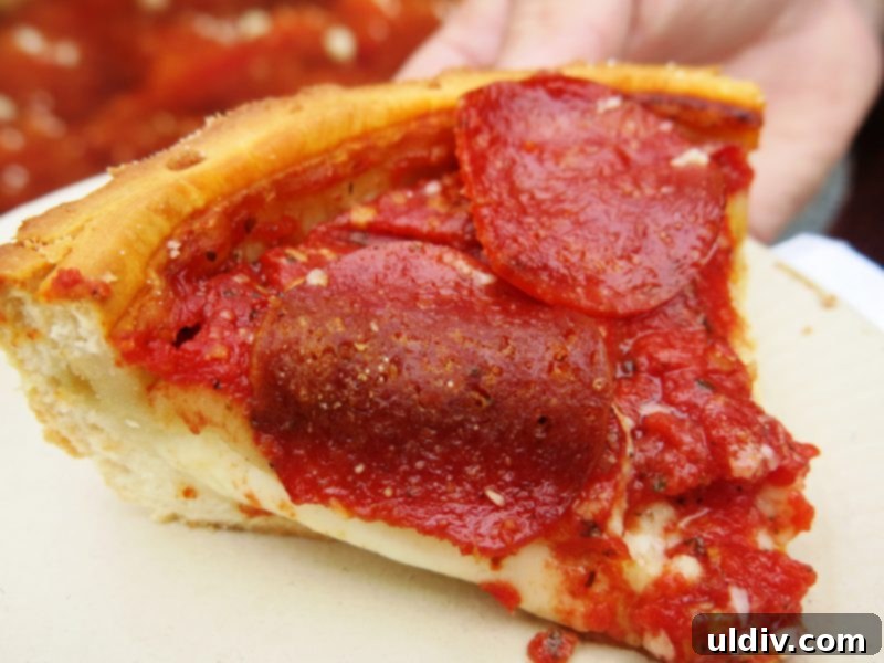 Deep Dive into Chicago Deep Dish 5 A vibrant, mouth-watering close-up of a deep dish pizza slice with abundant cheese pull, showcasing its rich layers and golden crust.