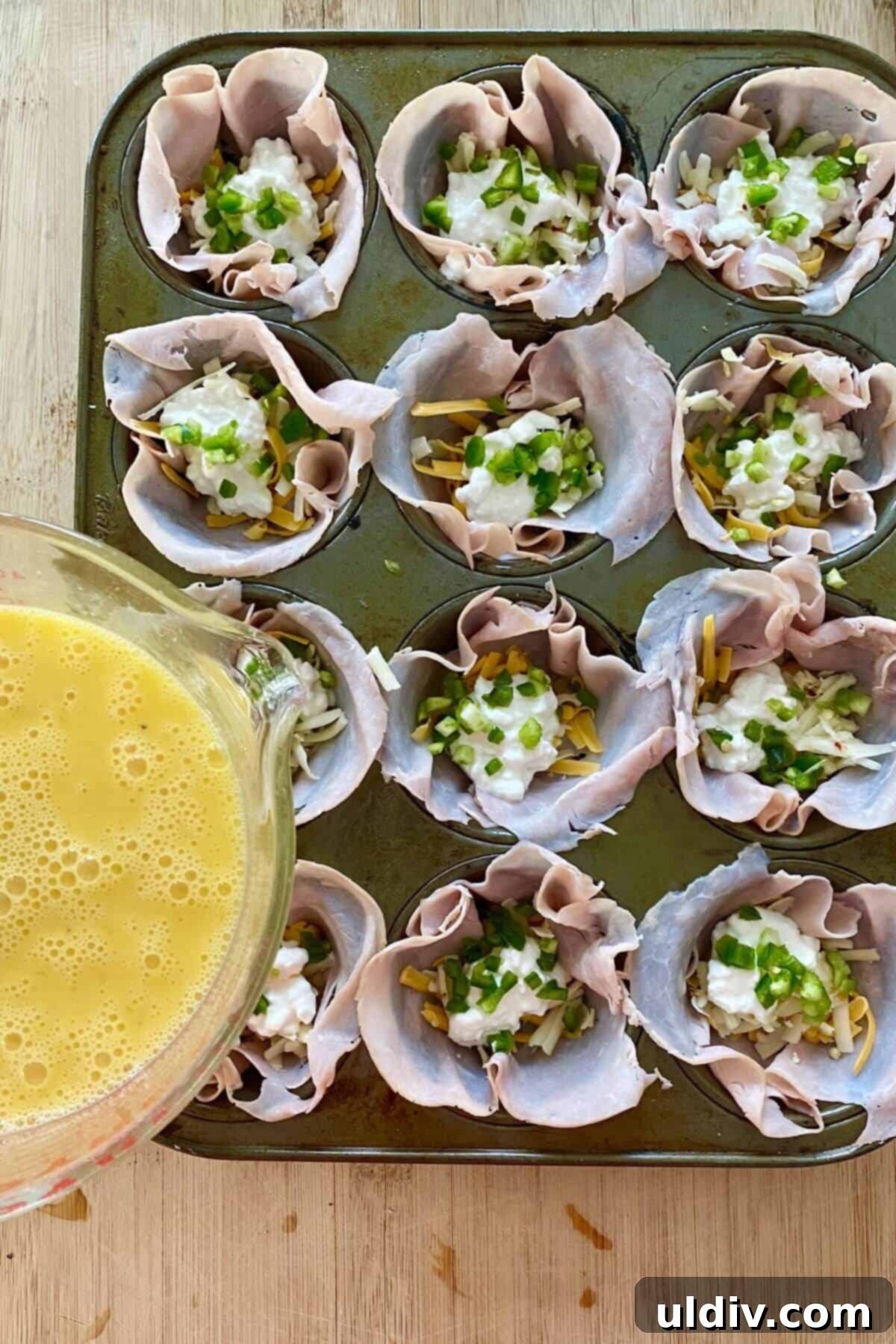 Fiery Popper Breakfast Bites 6 filling egg cups with beaten egg.