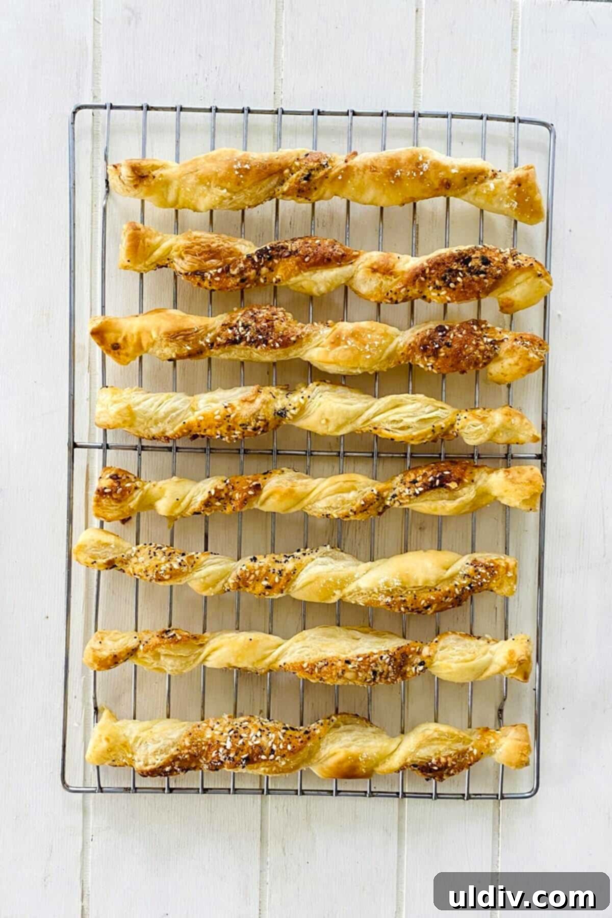 Flaky Everything Bagel Cheese Twists 9 Golden, crispy cheese twists cooling on a wire rack after baking.