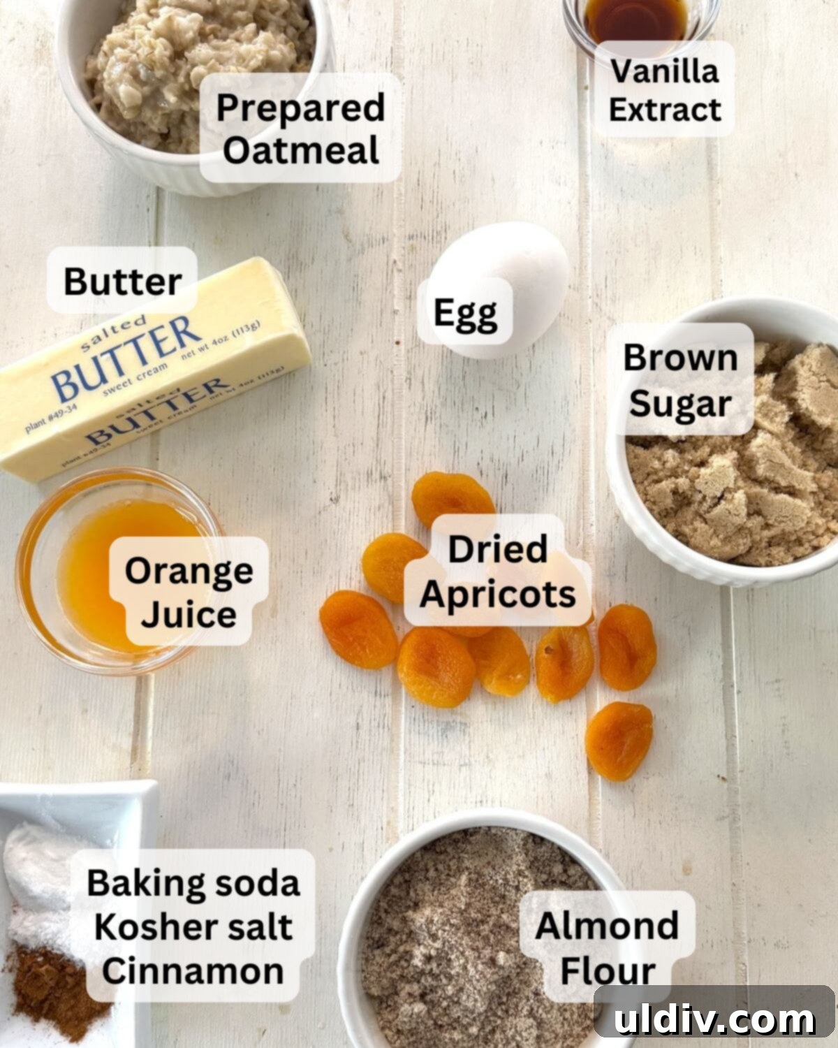 The Best Breastfeeding Lactation Cookie Recipe 4 Prepared oatmeal, dried apricots, egg, brown sugar, almond flour, and butter arranged on a wooden board, showcasing key ingredients for lactation cookies.