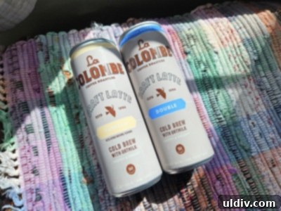 May's Top Product Picks 13 Three La Colombe Draft Latte cans artfully arranged, showcasing their brand and packaging.