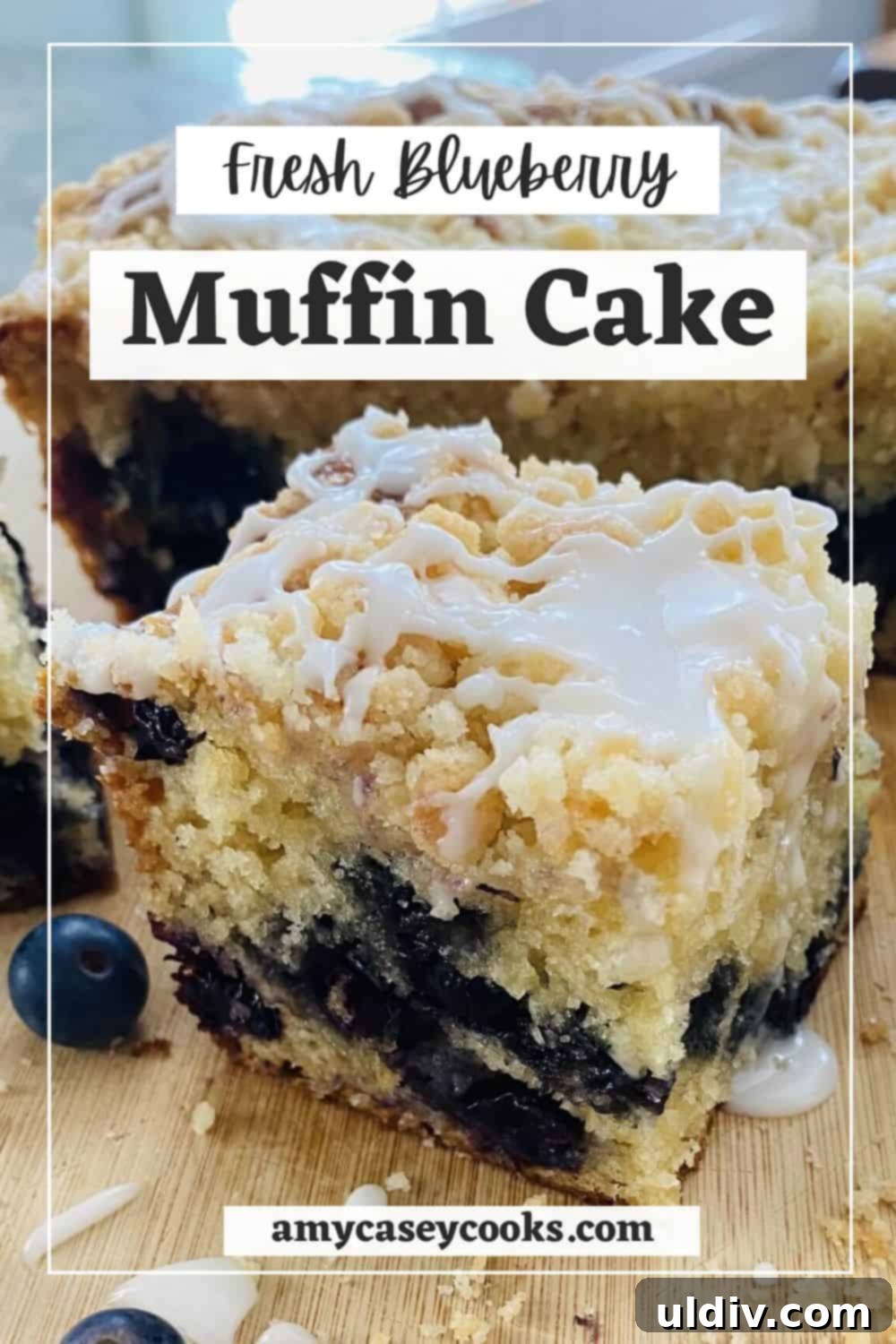 A slice of fresh blueberry cake with crumb topping, presented on a wooden cutting board.