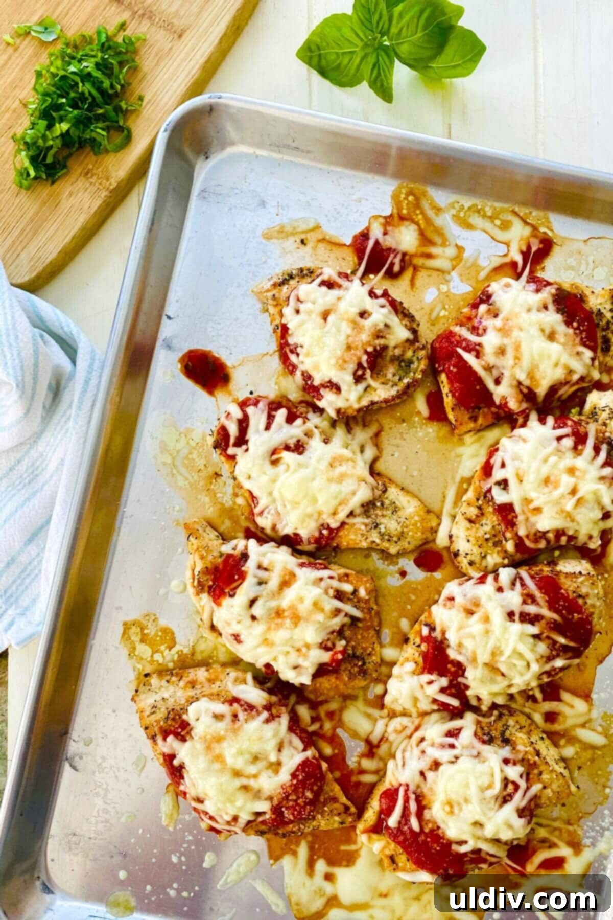 Quick and Healthy 20-Minute Low-Carb Chicken Parmesan 3 Fresh basil being sprinkled over a baked low carb chicken parmesan dish.