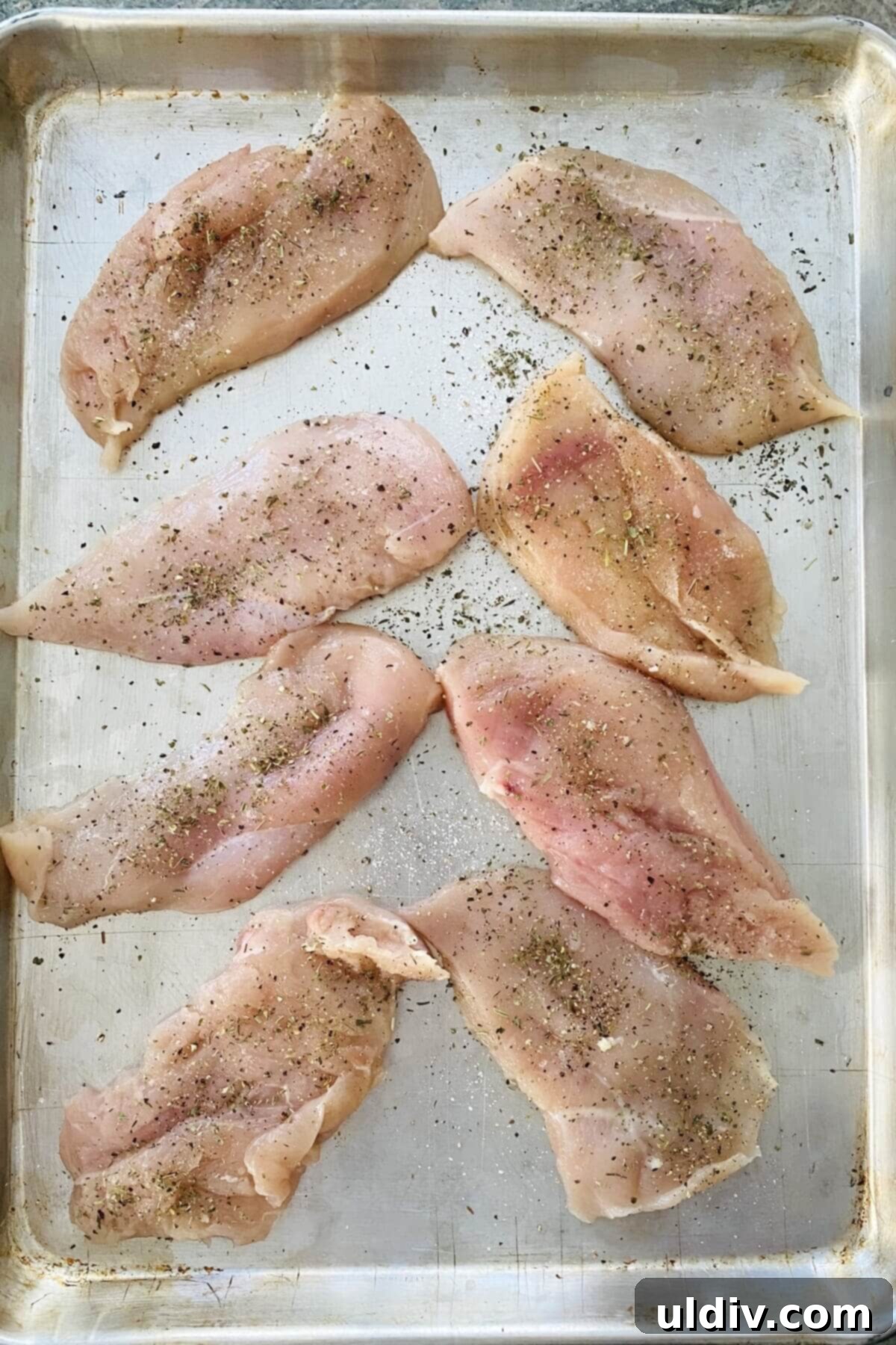 Seasoned chicken cutlets ready for cooking for parmesan.