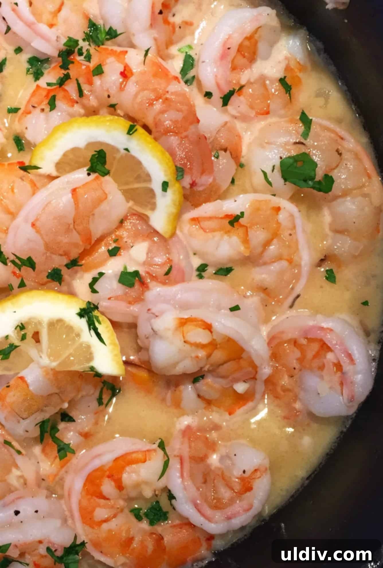 Zesty Lemon Garlic Shrimp Scampi 2 garlic butter shrimp scampi with lemons in a sauté pan.