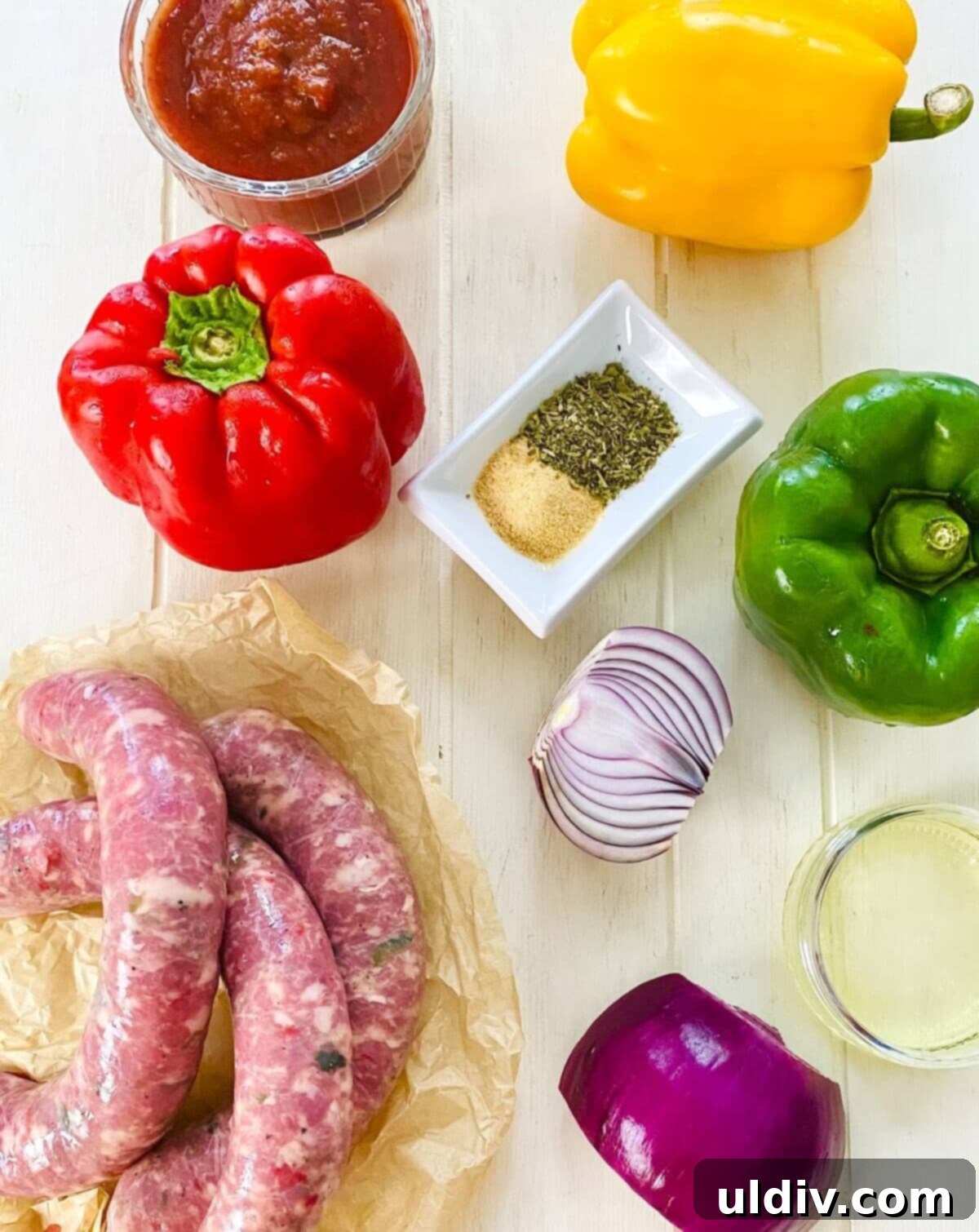Grilled Italian Sausage & Veggie Skewers 3 Italian sausage links, colorful bell peppers, red onion, marinara sauce, and olive oil laid out as ingredients.