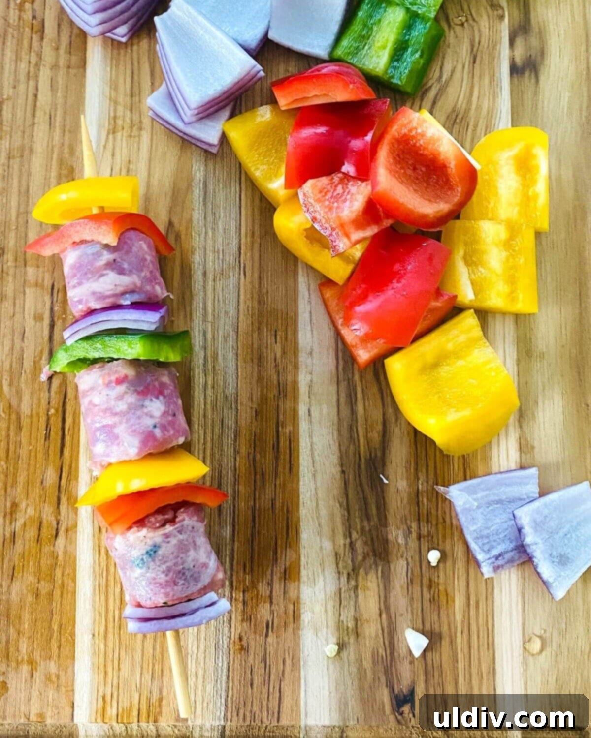 Grilled Italian Sausage & Veggie Skewers 5 Sausage kabobs arranged on a cutting board, ready for grilling.