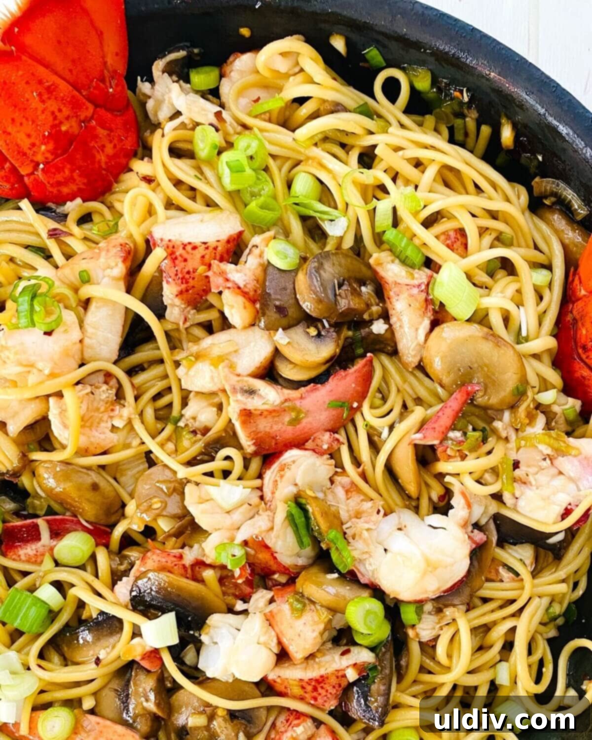 Decadent Garlic Lobster Noodles 12 A close-up of a serving of Garlic Lobster Noodles, showcasing the perfectly coated linguine, tender lobster, and vibrant vegetables, ready to be enjoyed.
