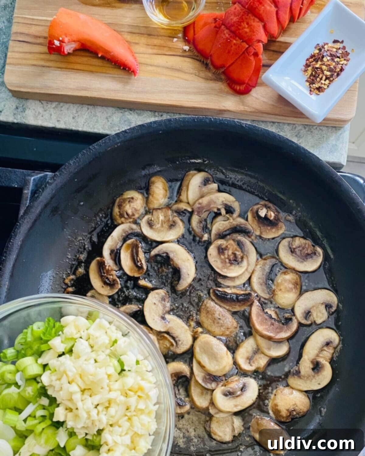 Decadent Garlic Lobster Noodles 6 Mushrooms, green onions, and minced garlic gently sautéing in butter in a large pan, building the aromatic base for the stir-fry.