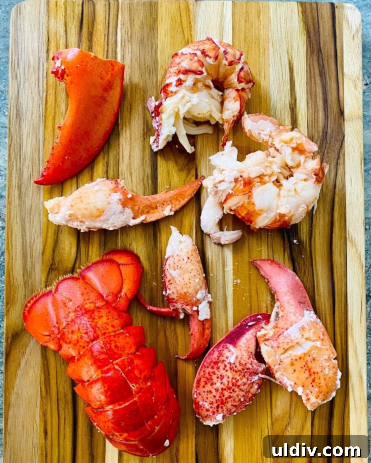 Decadent Garlic Lobster Noodles 7 Cooked lobster meat, neatly removed from its shell and cut into large pieces, beside the empty shells, ready for the noodle dish.