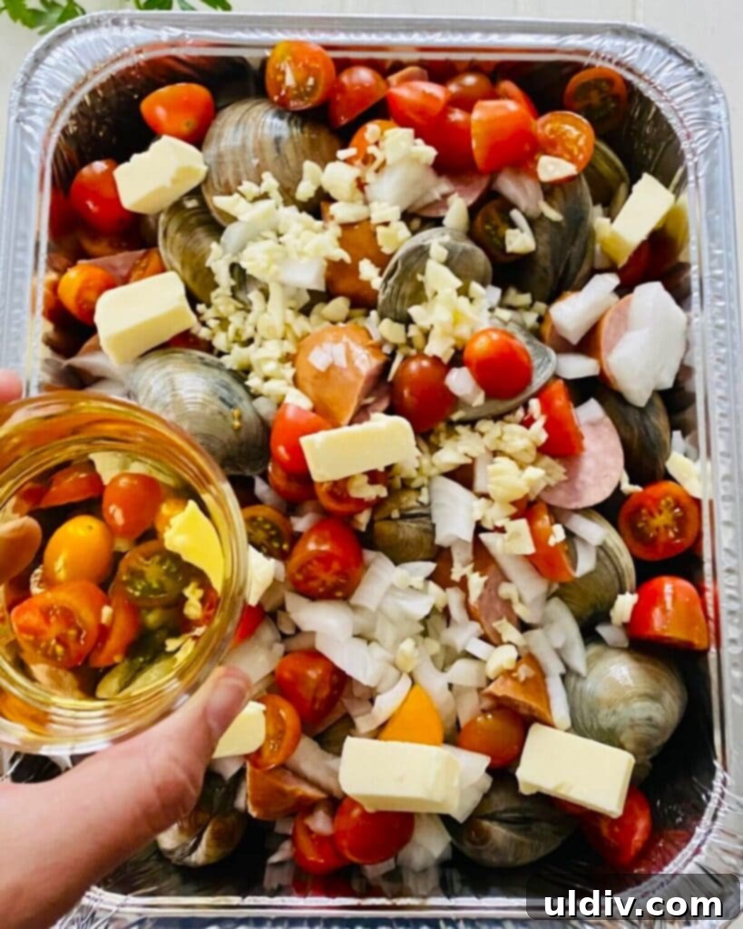 Rustic Drunken Clams with Kielbasa and Garlic 7 Dry white wine being poured over the shellfish and kielbasa in the pan.