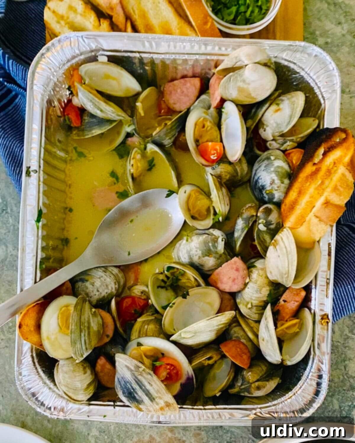 Rustic Drunken Clams with Kielbasa and Garlic 10 Drunken clams served in a foil pan, ready for a delicious dinner.