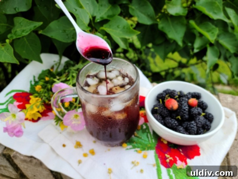Mulberries A Sweet Introduction 6 A glass of iced chamomile tea with mulberry syrup, garnished with fresh mulberries and a sprig of mint.