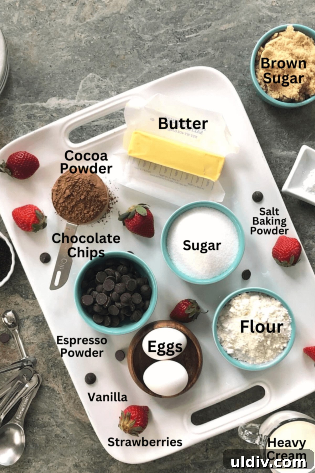 Ultra-Fudgy Chocolate Strawberry Brownie Bliss 4 A selection of ingredients laid out for making strawberry brownies, including butter, sugars, eggs, flour, cocoa powder, espresso powder, chocolate chips, and fresh strawberries.