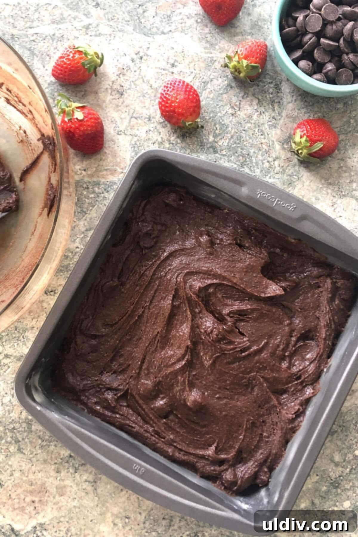 Fudgy Chocolate-Dipped Brownies with Fresh Strawberries 7 Thick chocolate brownie batter evenly spread into an 8x8 inch square baking pan, ready for the oven.