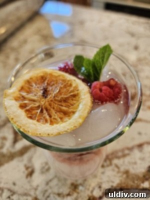 Virgin Piña Bliss 6 A hand holding a tropical Piña Colada mocktail with lush green foliage in the background, embodying summer relaxation.