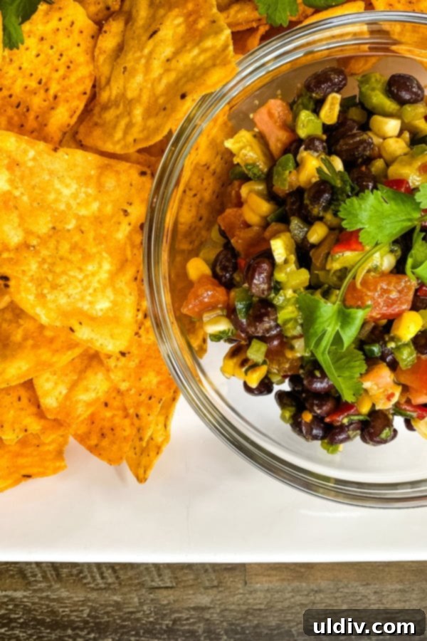 Zesty Bean and Avocado Texas Caviar 2 A bowl of vibrant Texas caviar bean and corn dip served with crunchy tortilla chips, ready to be enjoyed.