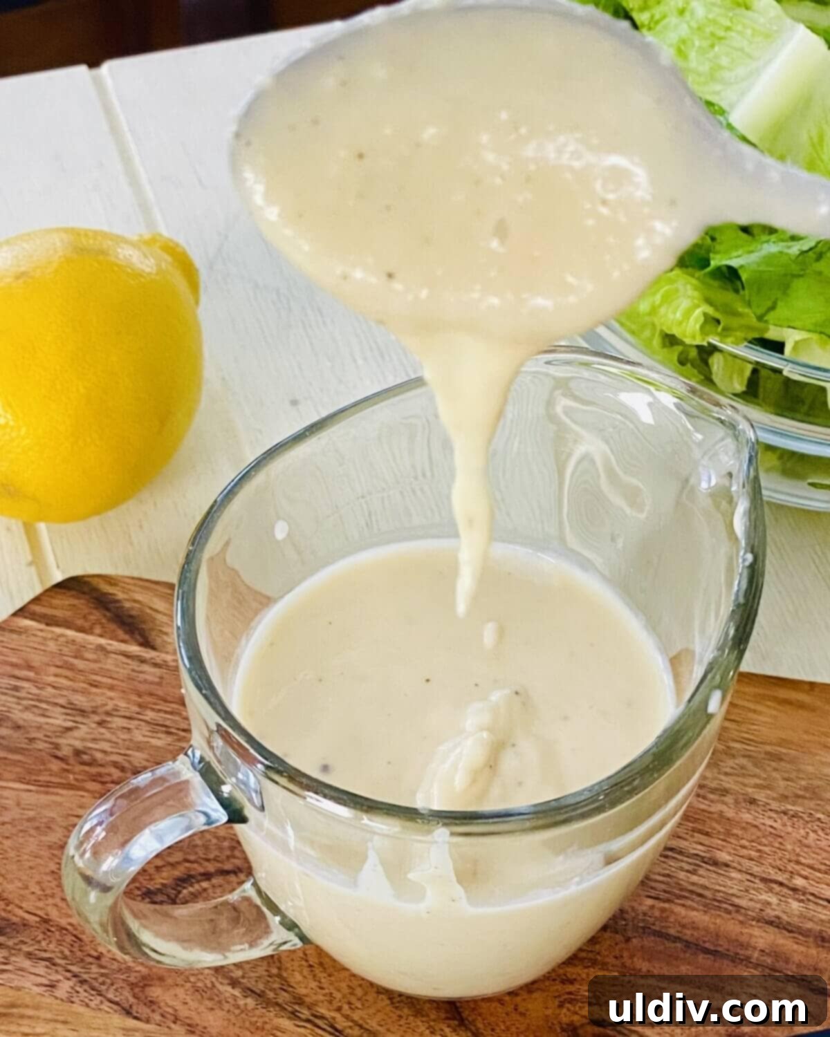 Homemade Caesar Dressing No Anchovies 11 Caesar dressing drizzling off a spoon.