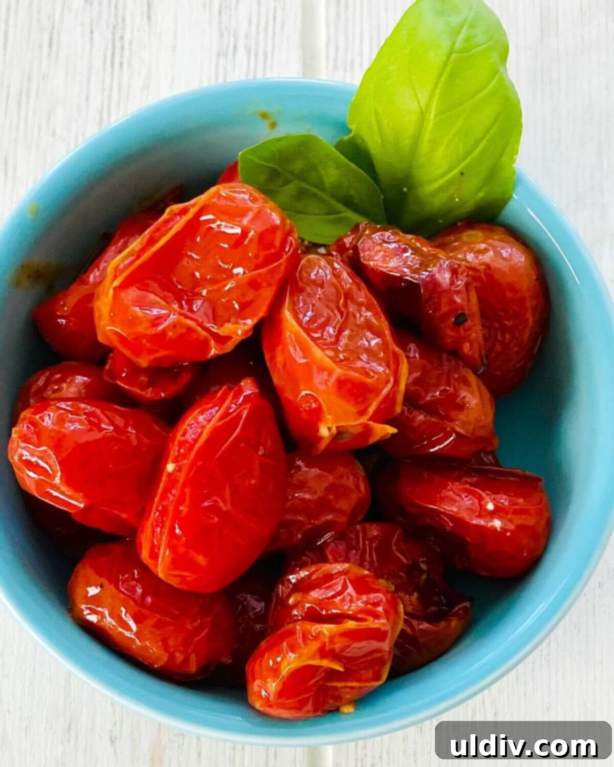 Sweet Oven Roasted Cherry Tomato Pasta 10 A rustic white bowl filled with chunky oven roasted cherry tomato sauce, garnished with fresh basil leaves, ready to be served.